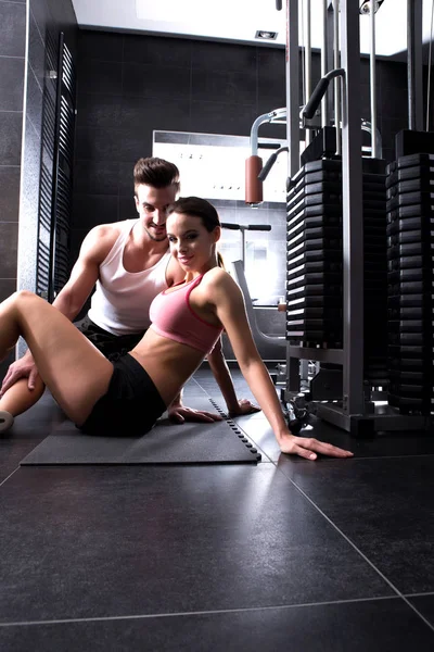 Young woman with her personal trainer in the Gym — Stock Photo, Image