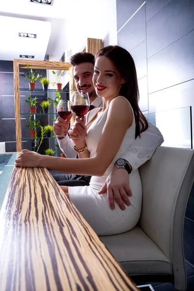 Um casal romântico com um copo de vinho na sala de jantar — Fotografia de Stock