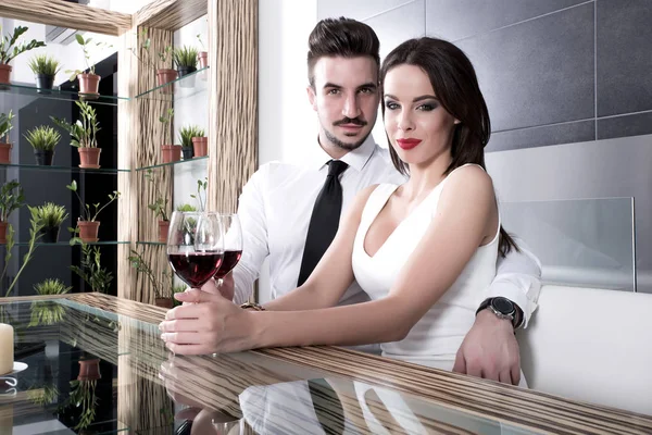 A romantic couple with a glass of wine in the dining room — Stock Photo, Image