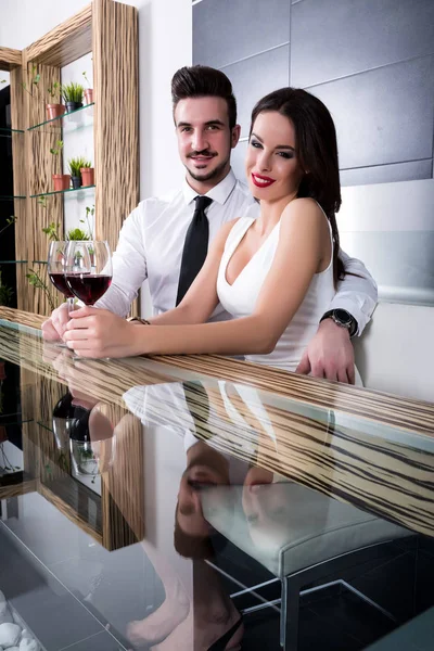 Ρομαντικό ζευγάρι με ένα ποτήρι κρασί στην τραπεζαρία — Φωτογραφία Αρχείου