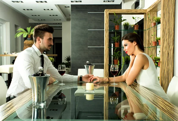 A romantic couple with a glass of wine in the dining room — Stock Photo, Image