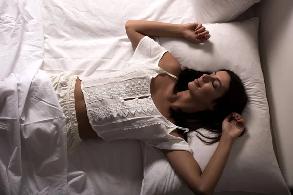 Hermosa mujer acostada en la cama por la noche —  Fotos de Stock