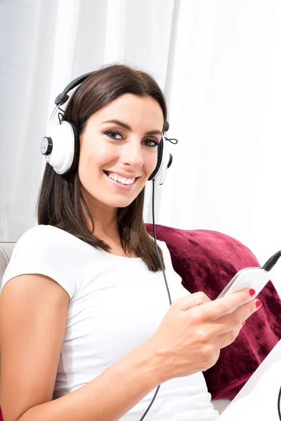 Hermosa mujer joven en auriculares escuchando música —  Fotos de Stock