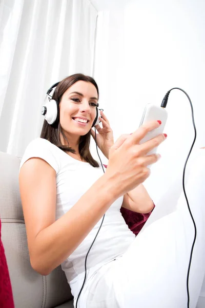 Mooie jonge vrouw in koptelefoon luisteren naar muziek — Stockfoto