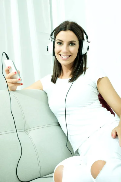 Hermosa mujer joven en auriculares escuchando música —  Fotos de Stock