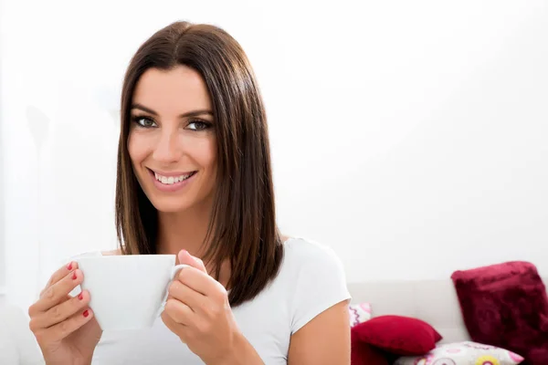 Vacker kvinna dricker kaffe hemma — Stockfoto