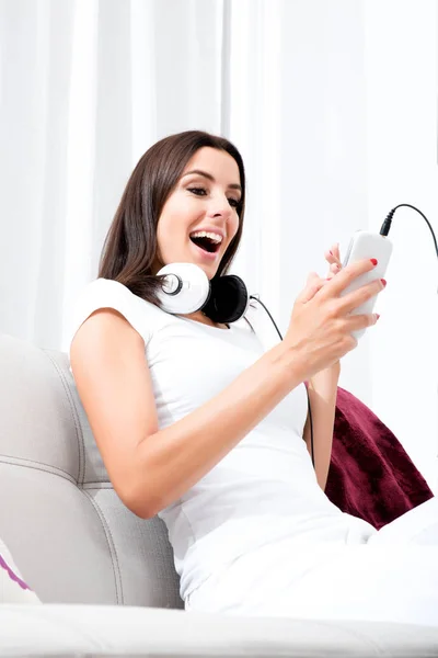 Beautiful young woman in headphones listening to music — Stock Photo, Image