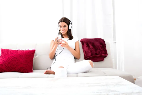 Mooie jonge vrouw in koptelefoon luisteren naar muziek — Stockfoto