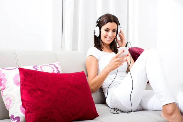Gyönyörű fiatal nő fülhallgató hallgat zenét — Stock Fotó