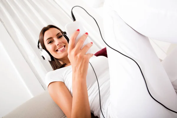 Hermosa mujer joven en auriculares escuchando música —  Fotos de Stock