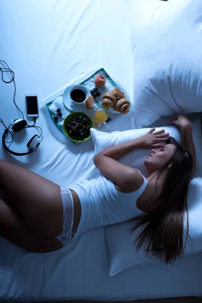 Een mooie jonge vrouw die nog steeds in slaap met ontbijt op bed — Stockfoto