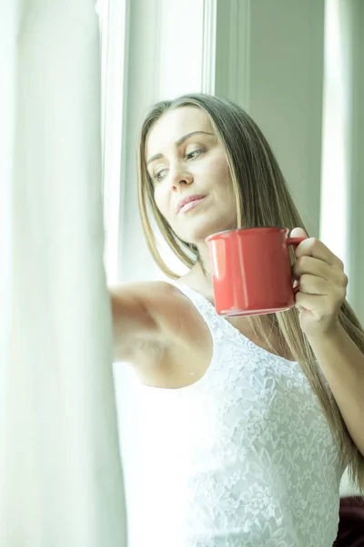 Vacker kvinna dricker kaffe hemma — Stockfoto