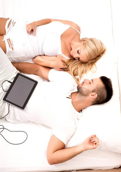 Güzel genç çift yatakta bir Tablet PC'yi kullanma — Stok fotoğraf