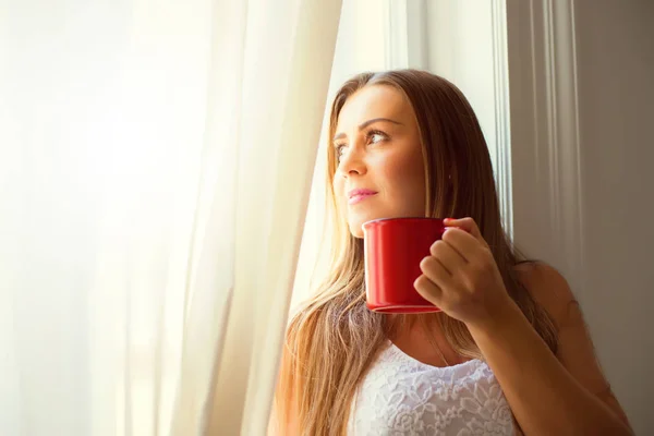 Vacker kvinna dricker kaffe hemma — Stockfoto