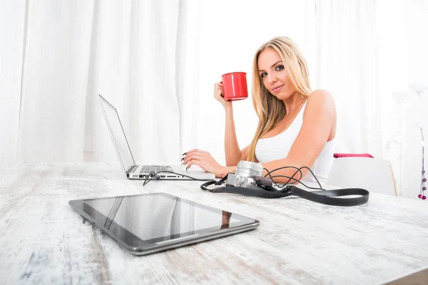 Eine schöne junge Frau an einem Tisch — Stockfoto