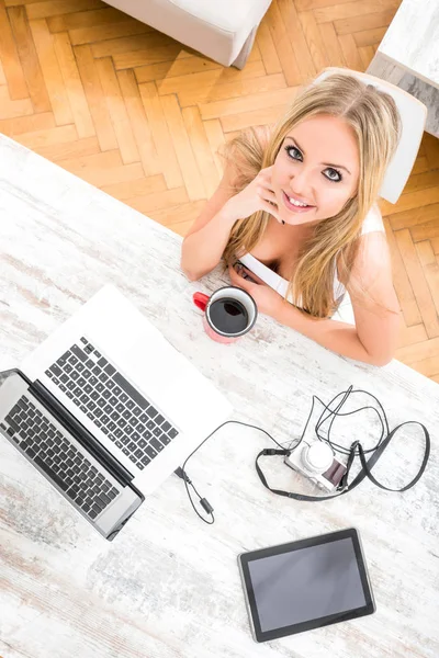 Uma bela jovem mulher a uma mesa — Fotografia de Stock