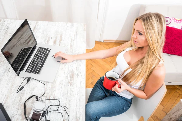 A beautiful young woman at a table — Stock Photo, Image