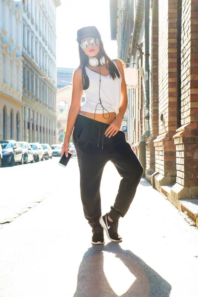 Hip hop girl com fones de ouvido em um ambiente urbano — Fotografia de Stock