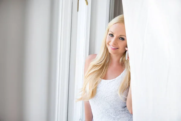 Una hermosa joven en la ventana — Foto de Stock