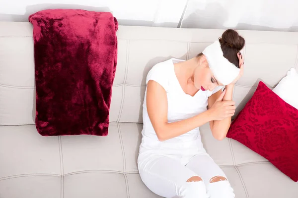 A beautiful young sick woman on the sofa — Stock Photo, Image