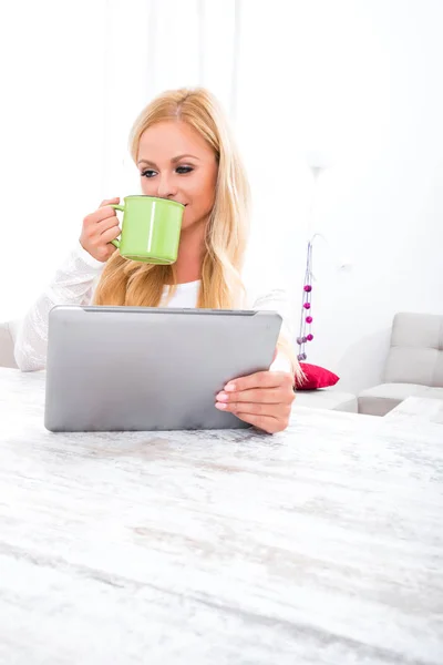 Eine schöne junge Frau an einem Tisch — Stockfoto