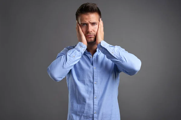 Hombre joven agarrando su cabeza — Foto de Stock