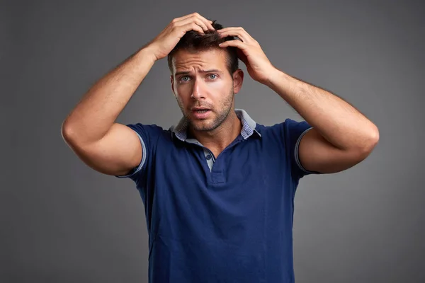 Jonge man die zijn haar controleren — Stockfoto