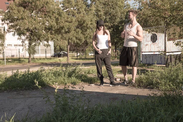 Casal jovem conversando em um ambiente urbano — Fotografia de Stock