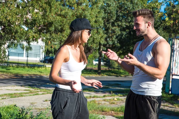 Casal jovem conversando em um ambiente urbano — Fotografia de Stock