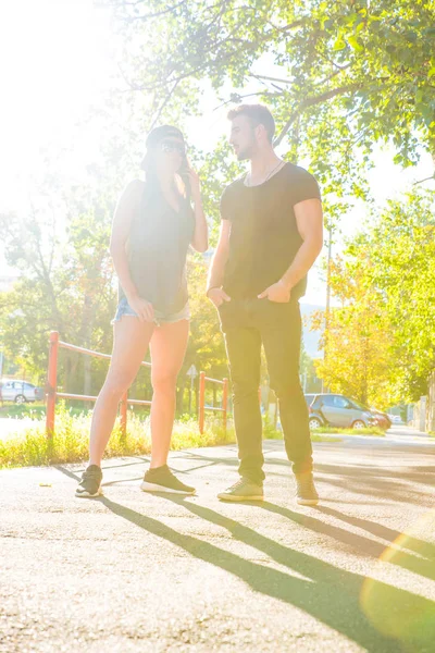 Fiatal pár beszél a naplementében, a városi környezetben — Stock Fotó