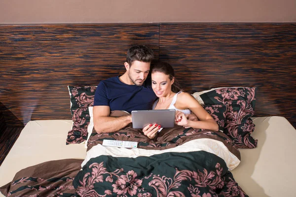 在床上使用 Tablet Pc 的美丽年轻夫妇 — 图库照片