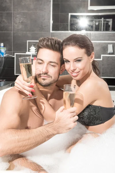 Hermosa pareja joven bebiendo Champagne en el Whirlpool —  Fotos de Stock