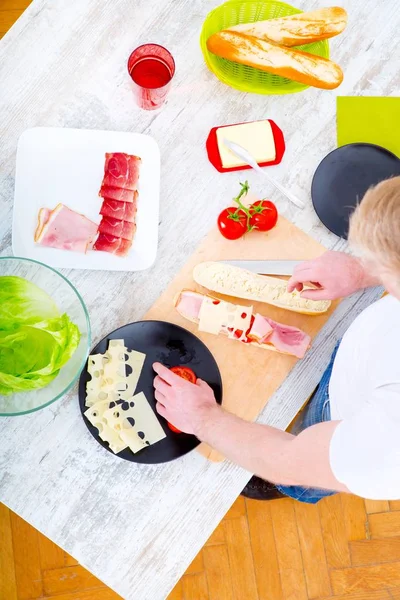 Jongeman bereidt een broodje voor — Stockfoto