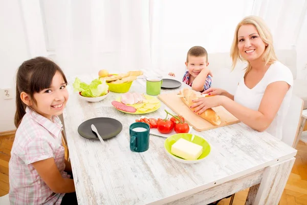 Mother and children having breakfast at home — Stock Photo, Image
