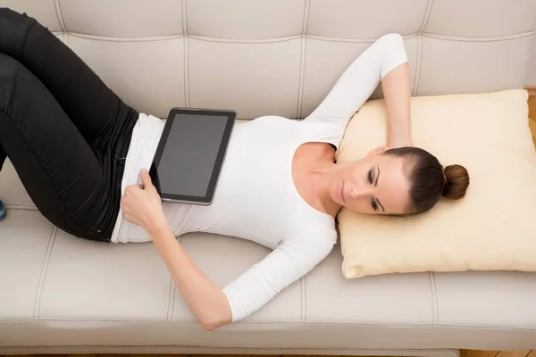 Junge Frau mit Tablet-PC auf dem Sofa — Stockfoto