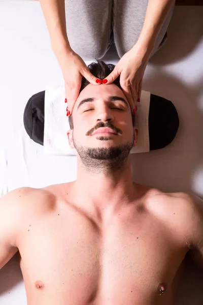 Una joven masajista aplicando un masaje en la cabeza —  Fotos de Stock