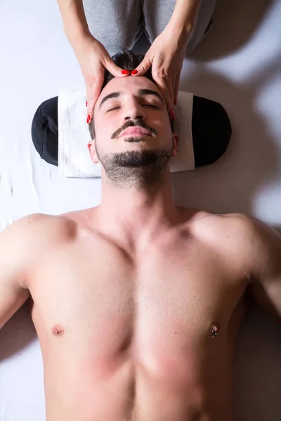 Молодой массажист делает массаж головы — стоковое фото