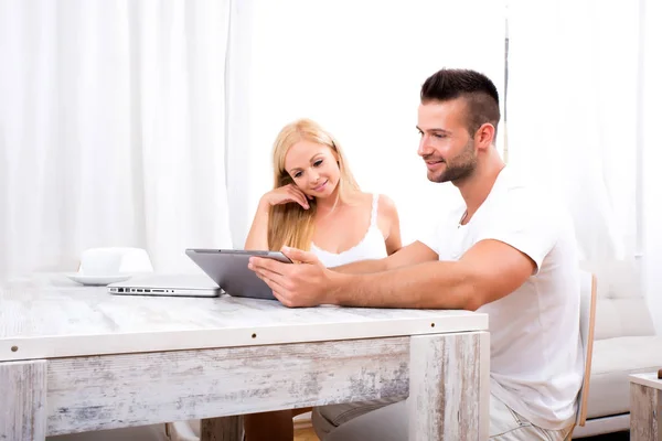 Красивая молодая пара, использующая планшетный компьютер вместе — стоковое фото
