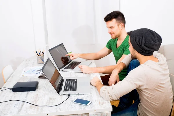 Twee jonge mannen aan het werk in het kantoor — Stockfoto