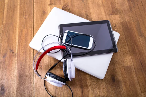 Digitale apparaten en koptelefoon op een houten desktop — Stockfoto