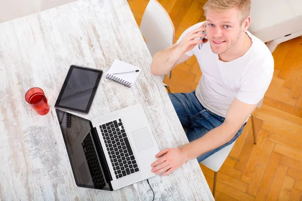A young caucasian man working in his home office. — Stock Photo, Image