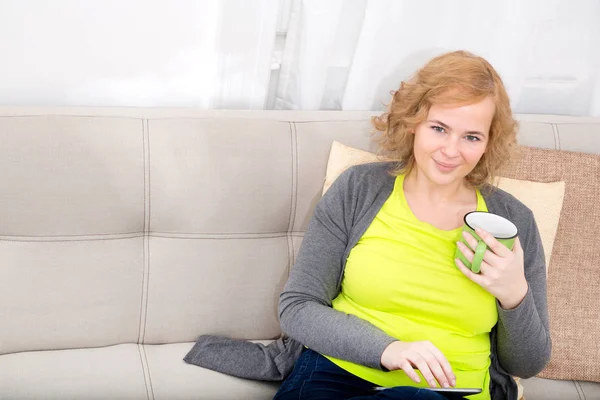 Молода жінка з планшетного ПК на дивані — стокове фото