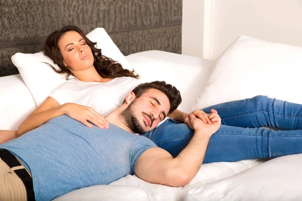 Young couple cuddling on the sofa at home — Stock Photo, Image