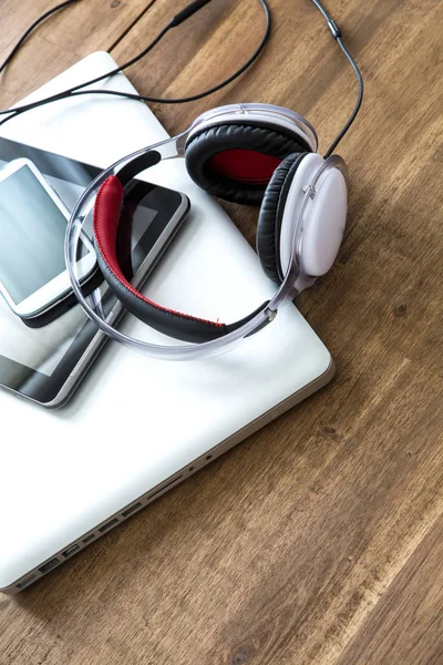 Ψηφιακές συσκευές και ακουστικά σε μια ξύλινη επιφάνεια εργασίας — Φωτογραφία Αρχείου