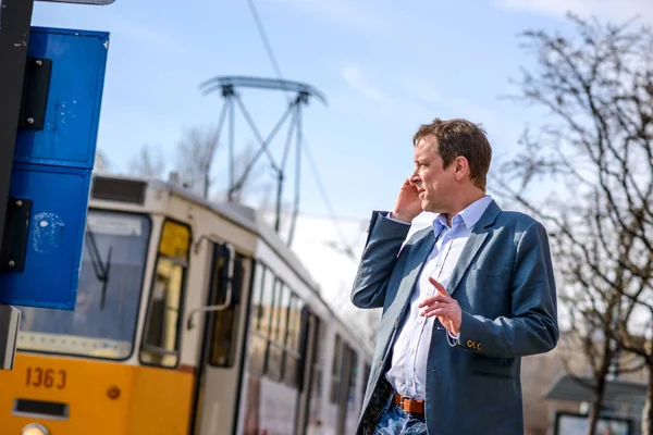 Een zakenman van middelbare leeftijd bij de tramhalte — Stockfoto