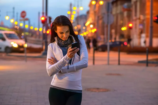 Ung kvinna på gatan med en telefon — Stockfoto