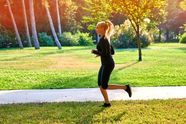 Giovane donna che corre in un parco — Foto Stock