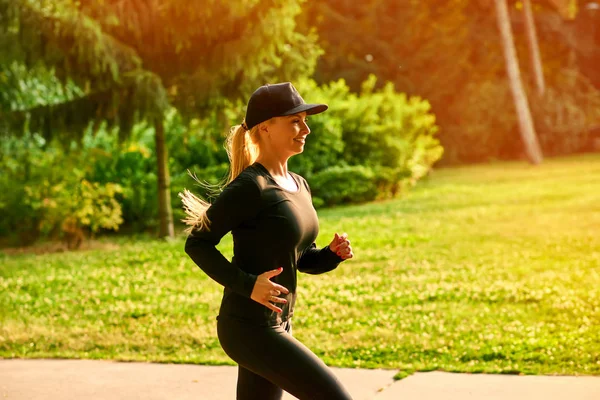 Ung kvinna springer i en park — Stockfoto