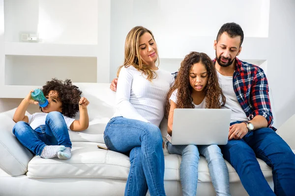 Jong gezin zittend op de bank — Stockfoto