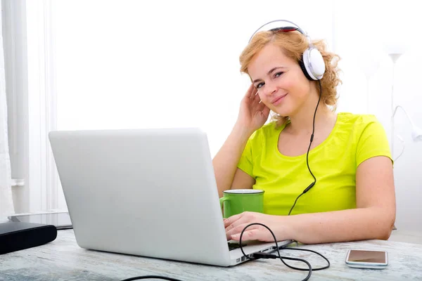 Young plus size woman listening to Audio while working on a lapt — Stock Photo, Image